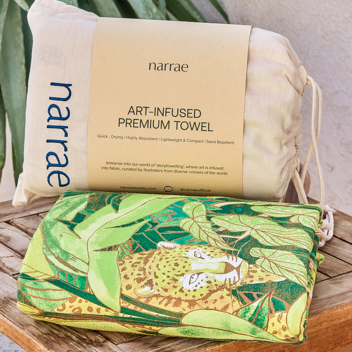 Saudade beach towel folded with its Narrae drawstring bag, showing the leopard in the artwork