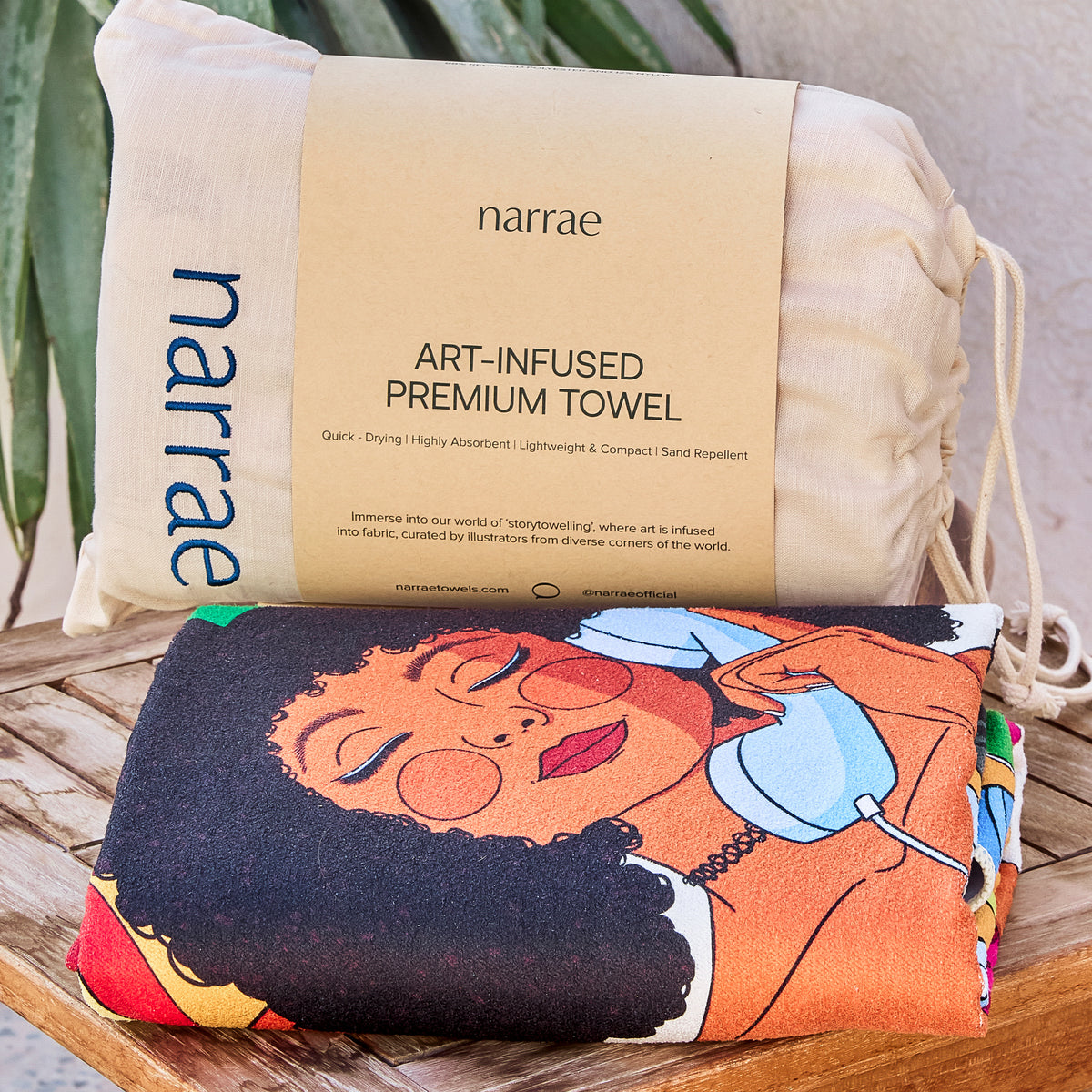 Sweet Reminiscence beach towel folded with its Narrae drawstring bag