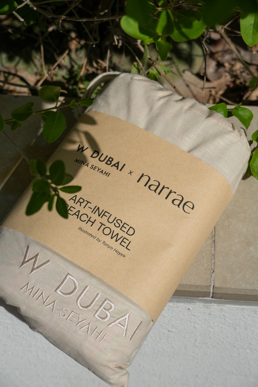 W Dubai x narrae kraft sleeve over the drawstring bag, with W Dubai Mina Seyahi embroidered below